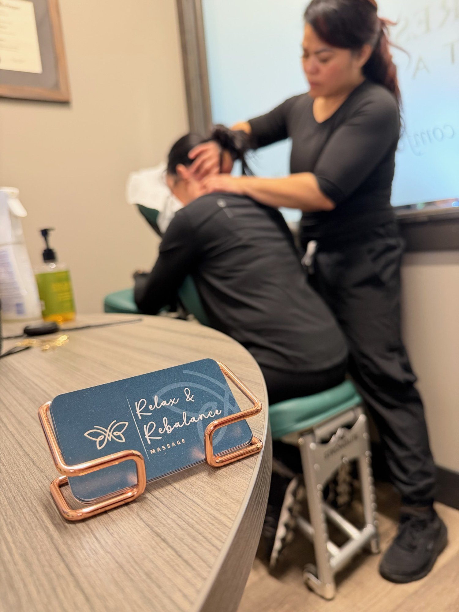 Relax and Rebalance business cards with a massage session in the background