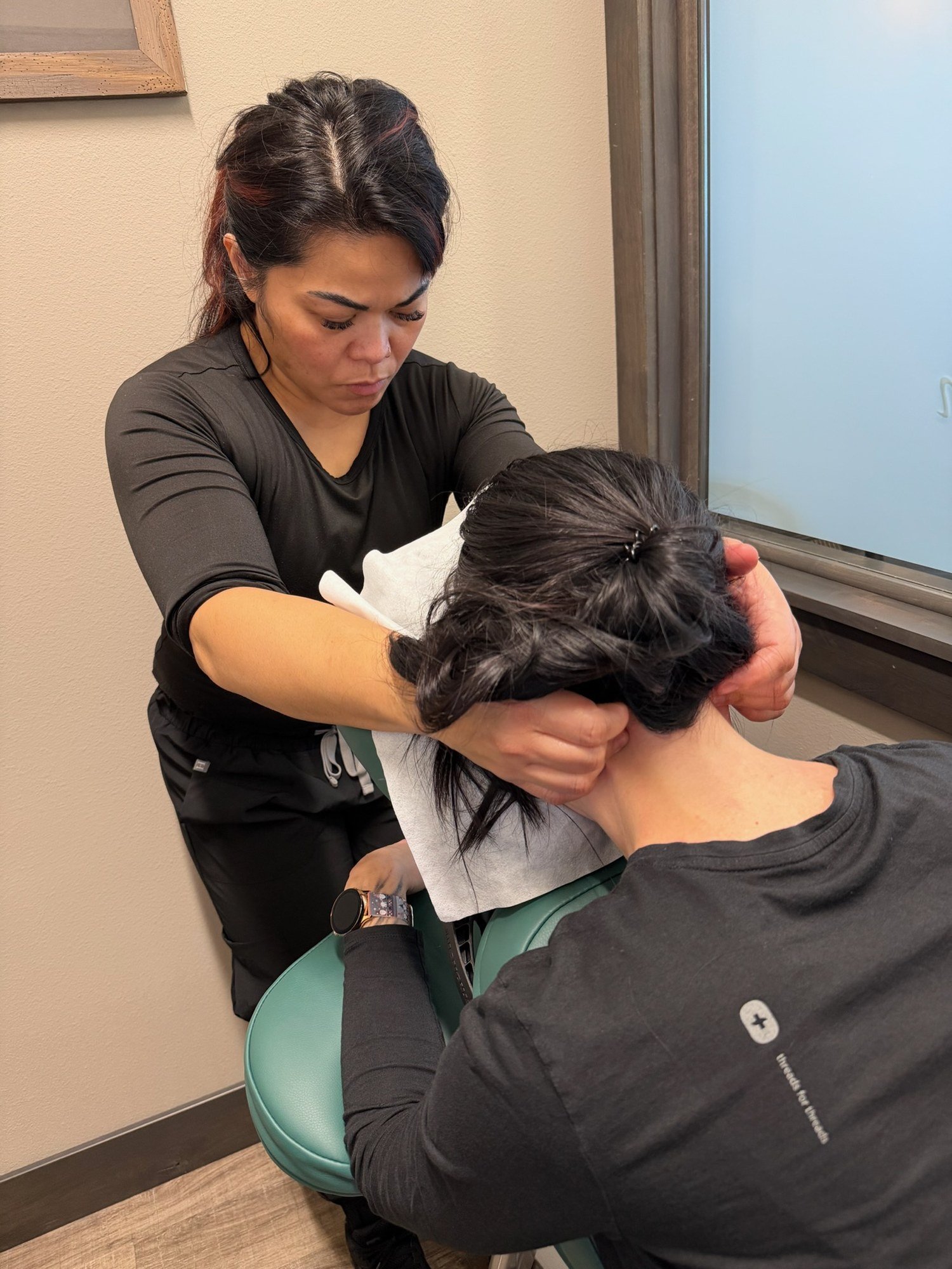 A practitioner providing a seated neck massage
