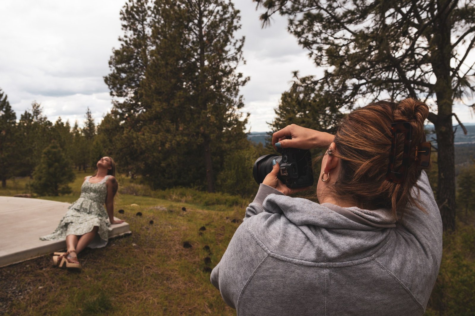 A photographer creating a portrait among pine trees