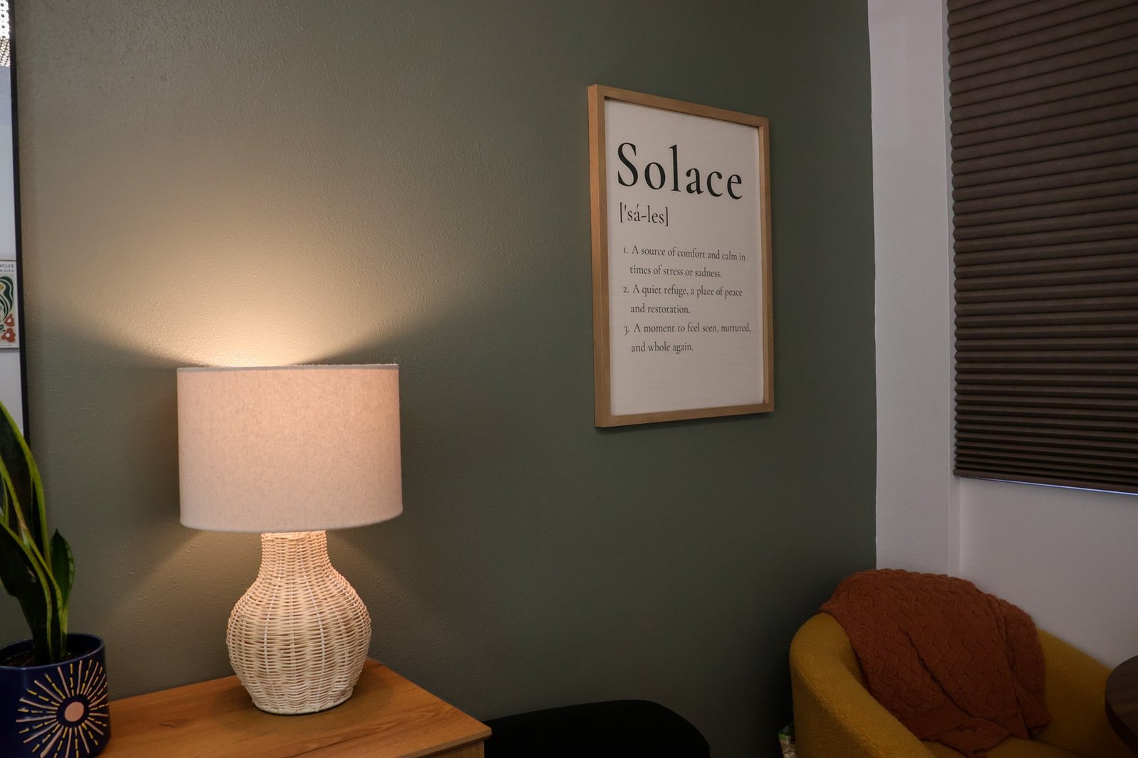 Warm lamp light and a framed Solace sign in a treatment room