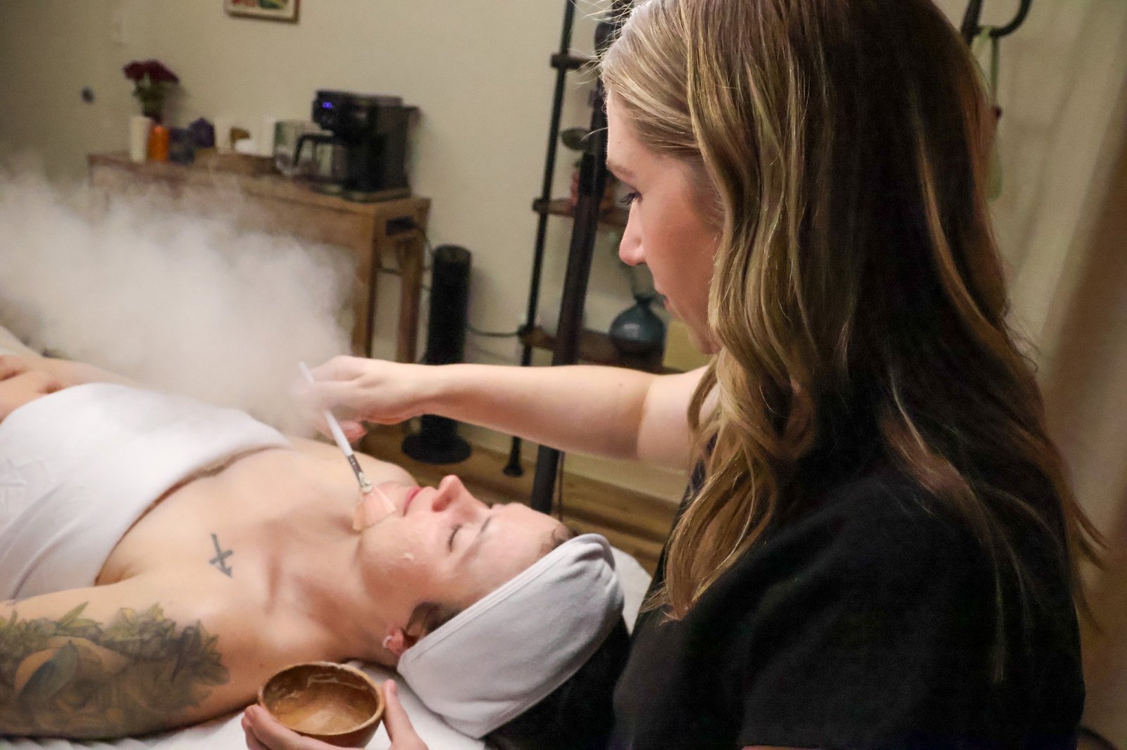 A skincare professional applying a facial mask