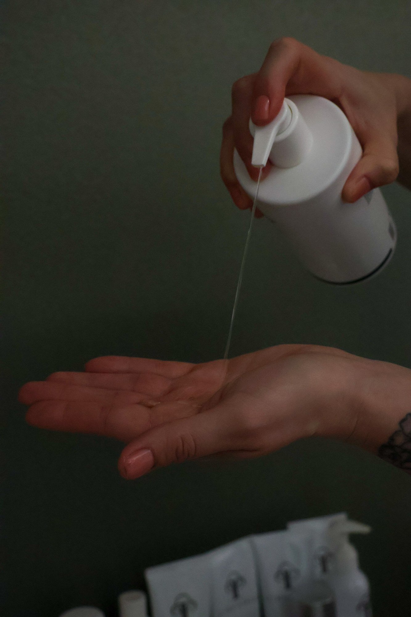 Skincare dispensed from a pump bottle into an open palm