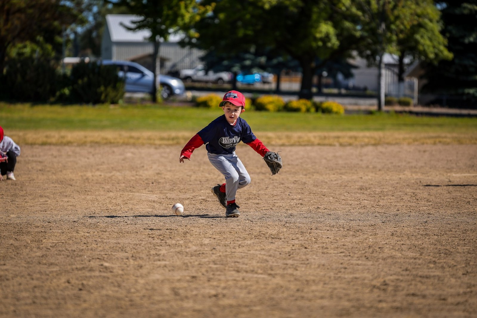 A young baseball player approaching a ground ball